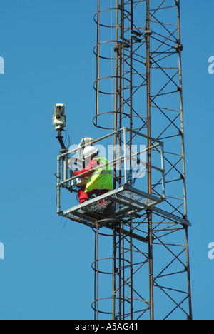 Man arbeitet an CCTV-Anlagen montiert Teil des Weges bis Flutlicht Turm Stockfoto