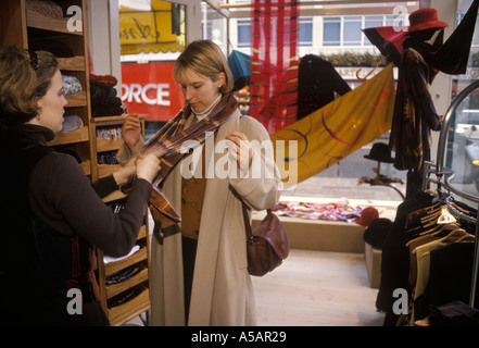 Ein Mitarbeiter hilft einem Kunden, einen Georgina von Etzdorf Schal im Knightsbridge Store anzuprobieren. London England 2014 2010er Jahre UK HOMER SYKES Stockfoto
