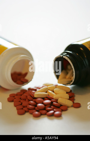Bunte Generika Tabletten Kapseln Medizin Spill aus 2 Container auf einem weißen Hintergrund Stockfoto