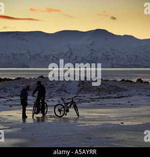 Jugendliche, die auf Fahrrädern, Winter Arktis Sonnenuntergang Stockfoto