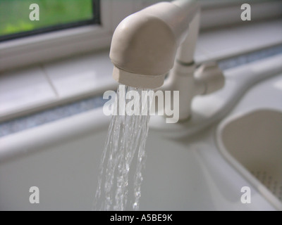 Küchenarmatur mit Wasser fließt (die Nachricht ist sinnvoll, wo Wasser betrifft, so liefert niedriger immer) Stockfoto