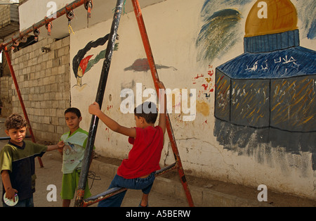 Kinder spielen vor einem Graffiti in Shatila Flüchtling Lager Beirut Stockfoto