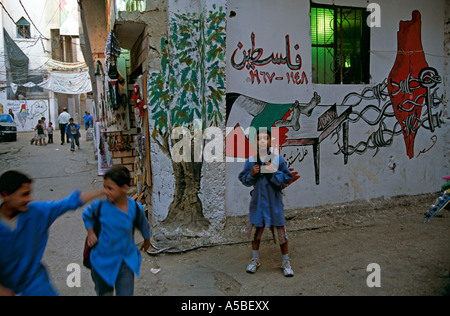 Schüler vor Graffiti an der Wand, Flüchtlingslager Shatila, Beirut, Libanon Stockfoto