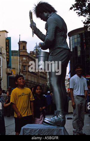 Kinder, die gerade ein Straßenkünstler in Leicester square London Stockfoto