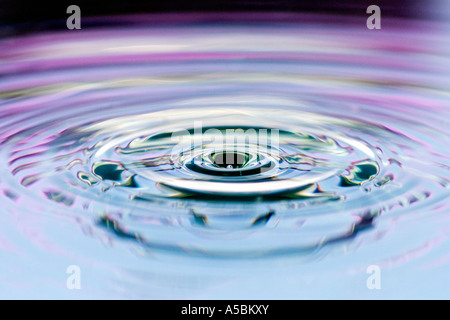 Wasser Tropfen abstrakt schwarz und rosa Hintergrund. Wasser auf eine Platte Spiegel reflektierte Farbe Stockfoto