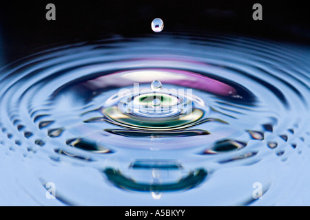 Wasser Tropfen abstrakt schwarz und rosa Hintergrund. Wasser auf eine Platte Spiegel reflektierte Farbe Stockfoto