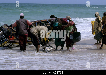 Menschen, die Annäherung an das Fischerboot für frisch gefangenen Fisch in Nouakchott, Mauretanien Stockfoto