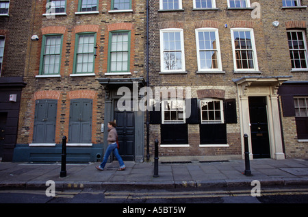 Ein Mann zu Fuß vorbei an der gut erhaltenen frühen georgischen nationalen Stadthäuser auf Fournier Street London Stockfoto