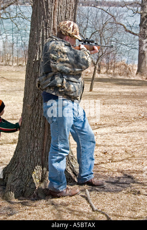 Vater zeigt rechts in der Passage mit Luftgewehr-Zielscheibe. Clitherall Minnesota USA Stockfoto