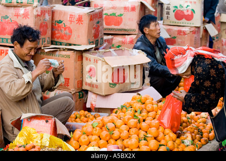 Akha Frau kaufen Orangen aus Xiding Markt Xishuangbanna China Stockfoto