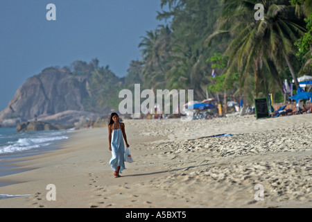 Frau im langen blauen Kleid Spaziergänge am frühen Morgen am Lamai Strand Ko Samui Insel Thailand Stockfoto