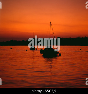 Festgemachten Jachten Silhouette gegen Nachleuchten von Sonnenuntergang, Oulton Broad, Suffolk, UK. Stockfoto