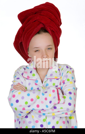 Ein junges Mädchen hat ein rotes Tuch auf dem Kopf, Schlafanzug trägt, hat ihre Arme verschränkt und ein dummes Gesicht macht. Stockfoto