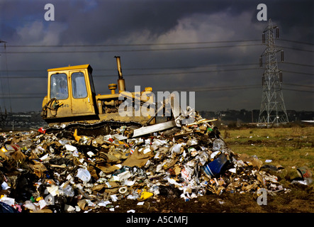 Bulldozer Müll auf der Deponie für neue Wege mit Sturmwolken sammeln Newport Gwent Wales UK Stockfoto