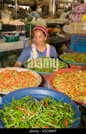 Frau, die Schüsseln mit einer Vielzahl von heißen scharfen Chilis, asiatische, asiatische Gemüsechilli, traditionellen Indoor Food Market, Provinz Krabi, Thailand verkauft Stockfoto