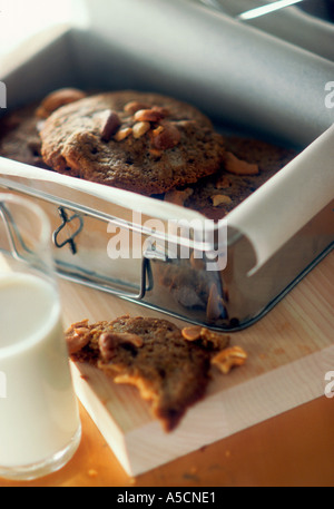 Hausgemachte Cookies in Metalldose mit Glas Milch Stockfoto