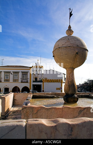 Portas de Moura Square gotischer Brunnen in Evora, Portugal. UNESCO-Welterbe. Cordovil House gotische Balkon auf der Rückseite gesehen. Stockfoto