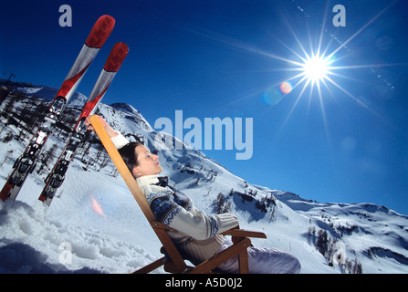 Frau auf Liegestuhl in Alpen, Seitenansicht Stockfoto