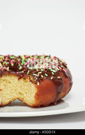 Schoko Donut mit Streuseln fehlt Biss auf Platte hautnah Stockfoto