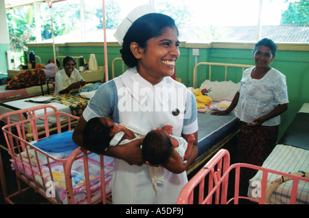 Hebamme hält neugeborenen Zwillinge in Geburtsklinik Kandy, Sri Lanka Stockfoto