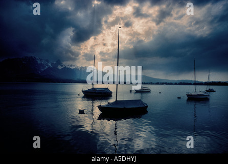 Yachten auf ruhiger See Gebirgswasser mit Verdunkelung ÖPNV dramatischer Himmel, Wellen von Licht mit den Alpen im Backgd, Interlak Stockfoto