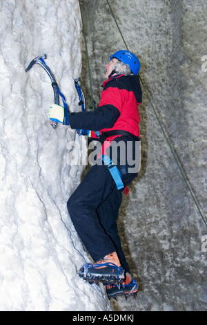 Weiblich, aufsteigend ein Eis Kletterwand im Eis Faktor Climbing Centre in Kinlochleven in Schottland Stockfoto