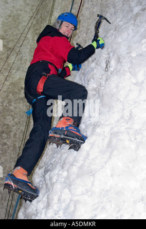 Weiblich, aufsteigend ein Eis Kletterwand im Eis Faktor Climbing Centre in Kinlochleven in Schottland Stockfoto
