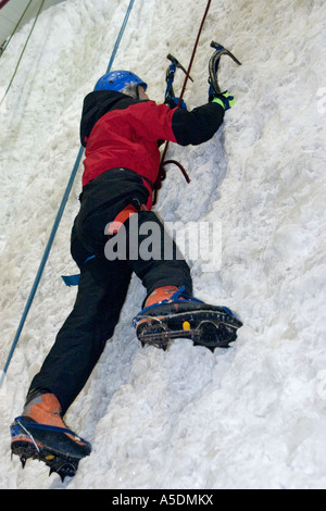Weiblich, aufsteigend eine Kletterwand am Eis Faktor Climbing Centre in Kinlochleven Schottland Eis Stockfoto