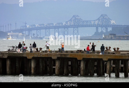 Menschen der Fischerei auf dem Pier und der Bay Bridge, San Francisco, Kalifornien, USA Stockfoto