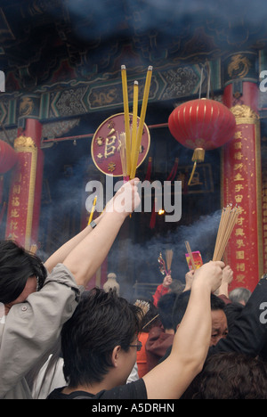 Anbeter brennende Räucherstäbchen während Lunar New Year Feiern im Wong Tai Sin Tempel, Kowloon zu halten. Hongkong, China Stockfoto