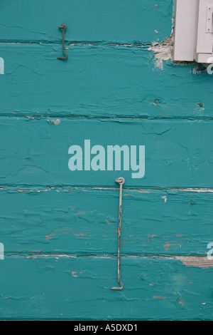 Zwei Haken ein kurzes und den anderen lange Dreh auf der Seite eine bunt bemalte aber abblätternde Wand Hopetown Abaco Bahamas Stockfoto