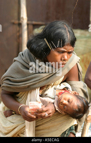 Dongria Kond Indianerin mit dem traditionellen Haar clips im Haar in Nursimg ihr Baby, Orissa, Indien Stockfoto