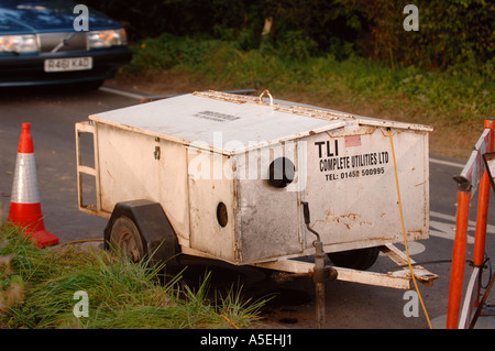 EINEN MOBILEN GENERATOR WIRD VERWENDET, UM TEMPORÄRE AMPEL AM A STRAßENARBEITEN UK MACHT Stockfoto