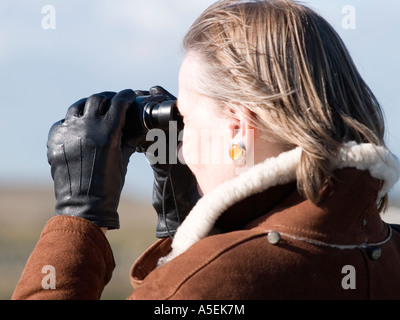 Frau, die durch ein Fernglas im nationalen Naturreservat Teesmouth Stockfoto