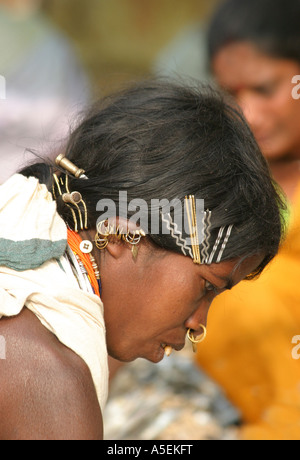 , Indianerin Dongria Kondh in Orissa, Indien tragen eine Masse von modernen Masse Haarspangen mit traditionellen Noserings und Ohrringe Stockfoto