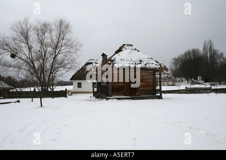 Schneebedecktes traditionelles ukrainisches Dorfhaus mit Strohdach. Stockfoto
