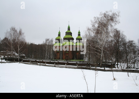 Traditionelle ukrainische Holzkirche in einer verschneiten Landschaft. Stockfoto