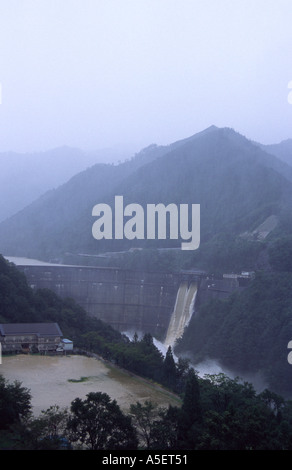 Die Schleusentore öffnen auf riesigen Damm bei Taifun Überschwemmungen. Das Gebäude im Vordergrund ist die Schule. Shiiba, Kyushu, Japan. Stockfoto