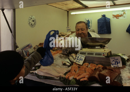 Ein Anbieter, der Verkauf von Lebensmitteln an seine Kunden in einem Markt in Notting Hill Gate London Stockfoto