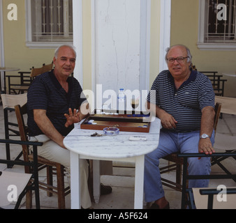 Zwei Männer pausieren und stoppen um zu posieren für die Kamera während einer Partie Backgammon in Zakynthos Stadt Zakynthos Insel der griechischen Inseln Stockfoto