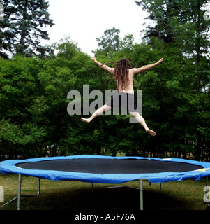 Junger Mann mit Dreadlocks springen auf einem Trampolin außerhalb Stockfoto