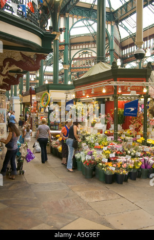 dh Kirkgate City Market LEEDS WEST YORKSHIRE Blumenverkäufer Shopper Blumenstände Blumenstände Blumenstand viktorianischer Ladenbau Blumen uk Floristen england Stockfoto