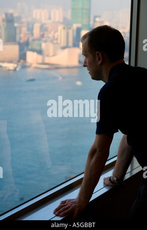 Mann auf der Suche die Hong Kong Skyline von einem hohen Gebäude Stockfoto