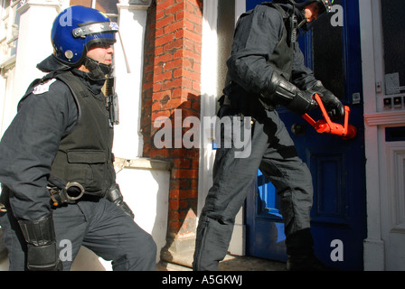 Polizist über geschlagenen Eierteig ab Haustür auf Raid eine Crack-Haus in West London, UK. Stockfoto
