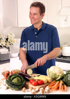 MANN IN DER KÜCHE VORBEREITEN GEMÜSE Stockfoto