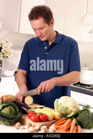 MANN IN DER KÜCHE VORBEREITEN GEMÜSE Stockfoto