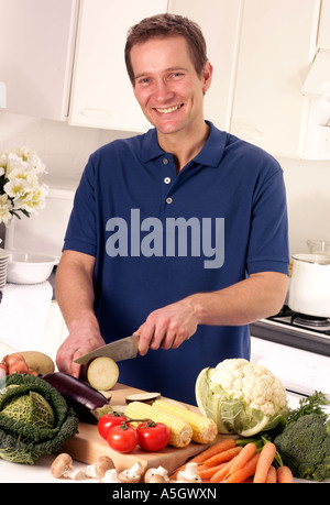 MANN IN DER KÜCHE VORBEREITEN GEMÜSE Stockfoto