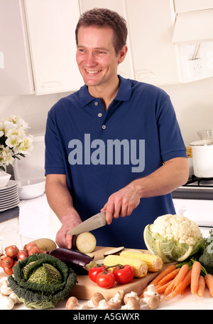 MANN IN DER KÜCHE VORBEREITEN GEMÜSE Stockfoto