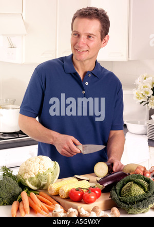 MANN IN DER KÜCHE VORBEREITEN GEMÜSE Stockfoto