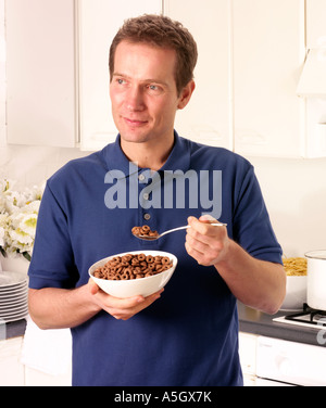 MANN IN DER KÜCHE ESSEN SCHOKOLADE MÜSLI Stockfoto
